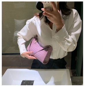 Mirror selfie showing the scale of the purple crocodile texture baguette bag