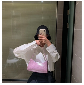 Close-up of trendy lavender crocodile pattern baguette bag worn with white shirt