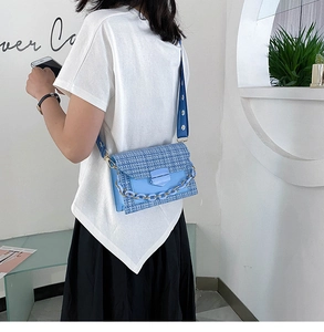 Detail of blue tweed crossbody bag featuring daisy print wide strap and resin chain link