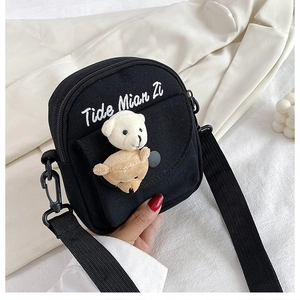 Detail of a black canvas crossbody bag featuring 3D plush bears and Tide Mian Zi embroidery