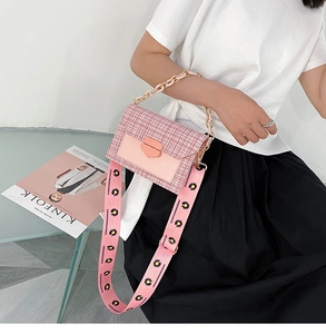 Close-up of pink tweed crossbody bag with daisy strap and chain handle on a model