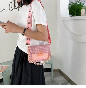 Detail of pink tweed crossbody bag with daisy wide strap and acrylic chain link