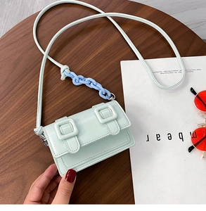 Bovenaanzicht van de mintgroene mini crossbodytas met glanzende afwerking en plastic ketting