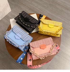 Detailed top view of colorful tweed crossbody bags with thick chains and daisy straps