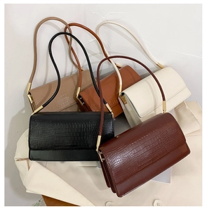 Detail showing five crocodile pattern underarm bags in black, brown, tan, beige, and white