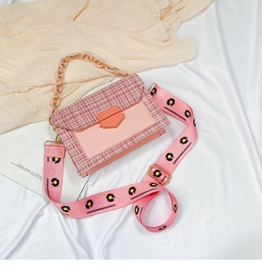 Close-up of pink tweed and leather crossbody bag with daisy chain and wide fabric strap