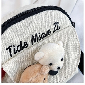 Detailed macro view of white canvas texture with cute plush bear and Tide Mian Zi embroidery