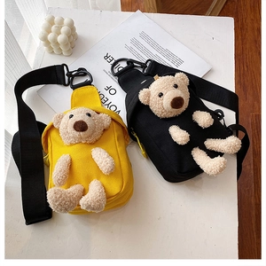Detail of canvas crossbody bag showing 3D plush bear and adjustable nylon wide strap
