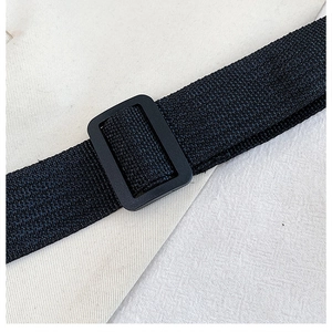 Detail of adjustable black canvas shoulder strap with matte black slider buckle for bags