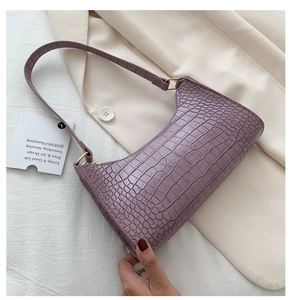 Close-up of purple crocodile texture underarm bag with elegant gold metal hardware buckle