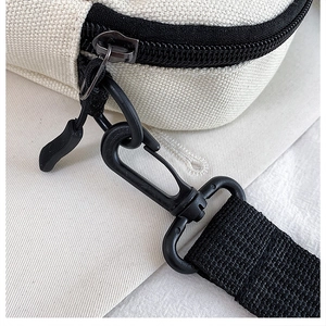 Close-up of durable black plastic swivel hook and nylon zipper on canvas bag