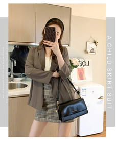 Detail of a chic black square chain shoulder bag paired with a stylish brown blazer outfit