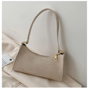 Detail of creamy white baguette bag showing high-quality crocodile pattern embossed leather