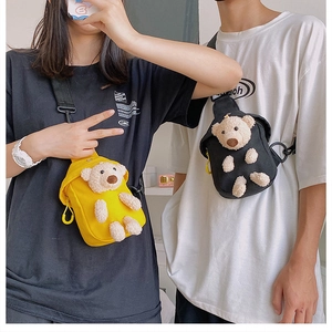 Detail showing the 3D plush bear motif on stylish yellow and black canvas chest bags