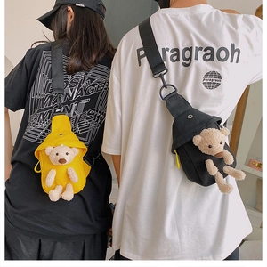 Detail view of canvas crossbody bags featuring 3D plush teddy bear in black and yellow