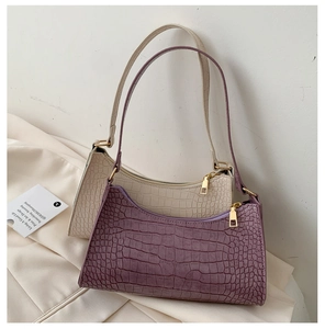 Detail view of purple and beige baguette bags with crocodile pattern on soft fabric