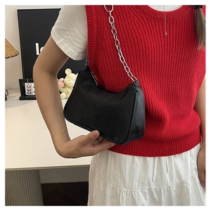 Detail of minimalist black leather underarm bag with thick silver metal chain strap