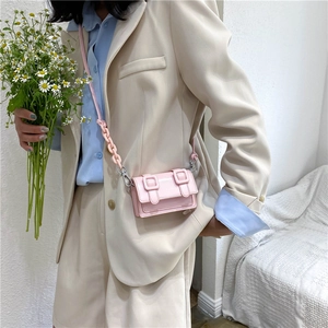 Roze mini crossbody tas met acryl ketting en dubbele riemen gedragen door model