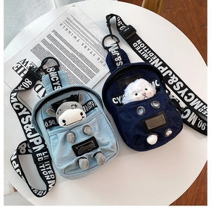 Detail of denim crossbody bags featuring 3D cartoon animal characters and wide lettered straps