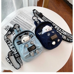 Detail of denim crossbody bags with cute cartoon motifs and wide logo webbing straps