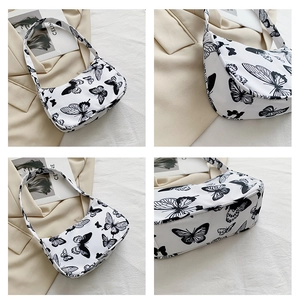 Detail view of canvas shoulder bag with black butterfly prints and retro style