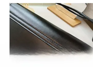 Detailed view of the precise stitching and premium black leather texture of the handbag