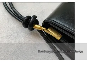 Detail of knotted leather shoulder strap with vintage gold hardware and stitching