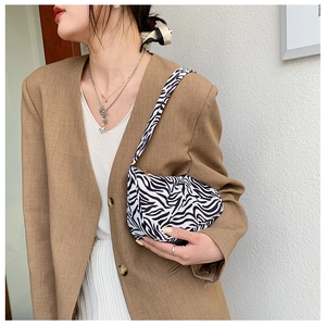 Fashionable zebra print shoulder bag styled with khaki blazer on a model