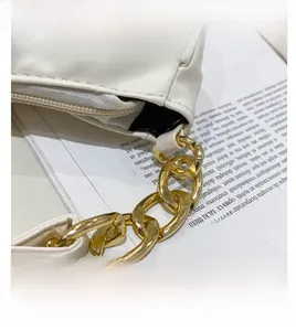 Detail of off-white pleated shoulder bag with gold chain strap and metal hardware buckle