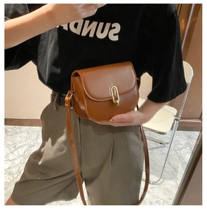 Braune Retro-Satteltasche aus Leder mit goldener Schnalle, als Umhängetasche getragen