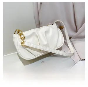 Close-up of white ruched hobo bag featuring a gold chain strap on a neutral background