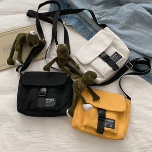 Three canvas messenger bags in black, beige, and yellow with adjustable wide straps