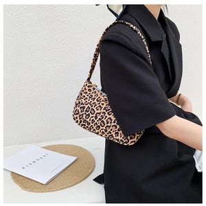 Detailed view of the trendy leopard print canvas baguette shoulder bag on a model