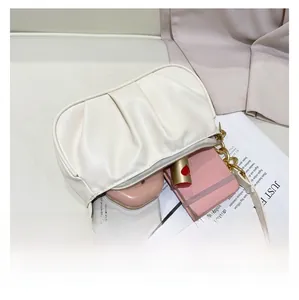 Top view of white pleated shoulder bag showing spacious interior for phone and notebook