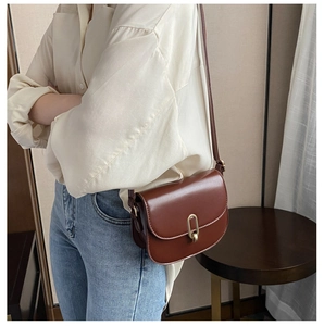 Details einer eleganten Satteltasche aus Leder mit goldener Schnalle am Modell