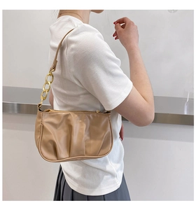 Detail of beige pleated shoulder bag with chunky gold chain link and soft PU leather texture