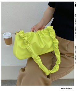 Detail of neon green pleated cloud bag featuring soft texture and stylish golden zipper