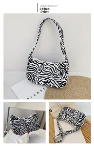 Three-way view of zebra pattern underarm bag featuring monochrome print and metal zipper
