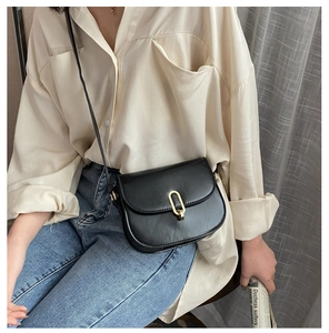 Detailansicht der schwarzen Satteltasche mit goldener Schnalle und Leder-Schultergurt