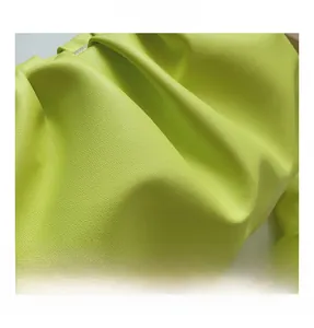 Macro shot of ruched lime green leathery fabric with premium litchi grain texture