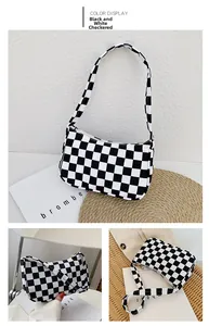 Close-up of black and white checkered underarm bag with golden metal zipper detail