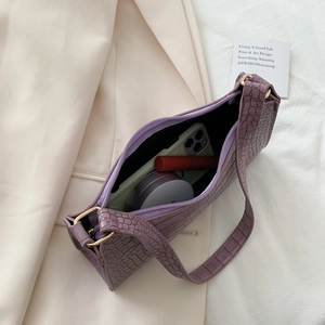 Purple crocodile pattern baguette bag showing interior space for phone and cosmetics