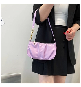 Detail of light purple pleated baguette bag with gold chain accent on shoulder strap