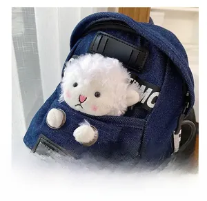 Detail shot of denim crossbody bag featuring a cute 3D plush lamb and metal logo plate