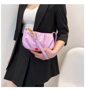 Detail of lilac ruched shoulder bag featuring a stylish gold chain and textured faux leather