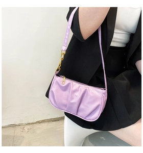 Detail of lilac pleated shoulder bag with gold chain strap shown on model's shoulder
