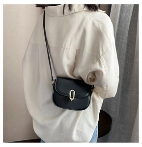 Elegante schwarze Satteltasche mit goldener Metallschnalle an einem Modell