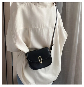 Nahaufnahme einer schwarzen Satteltasche aus Leder mit goldener Ringschnalle