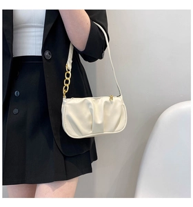 Detail of off-white pleated shoulder bag featuring elegant gold chain strap and PU leather