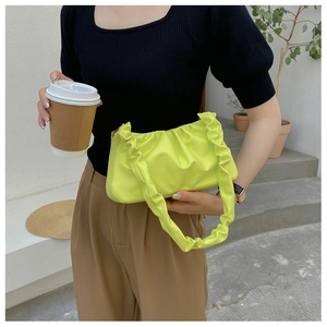 Detail of neon green pleated cloud bag with soft ruched texture and matching handle